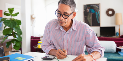 Man in glasses working on his finances at a desk