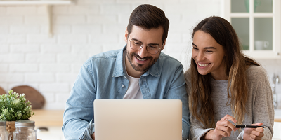 Couple looking at a laptop together, smiling