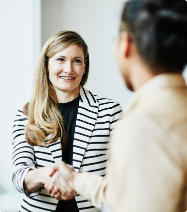 A woman shaking hands with her financial professional.