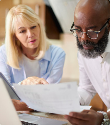 A man and woman reviewing a document about Immediate Benefit Accounts from Protective.