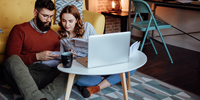 Millennial couple sitting on the floor, financial planning