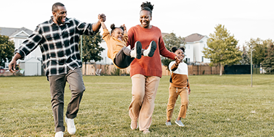 Young African American family with two kids outside playing