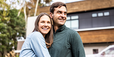 A wife hugging her husband, smiling.