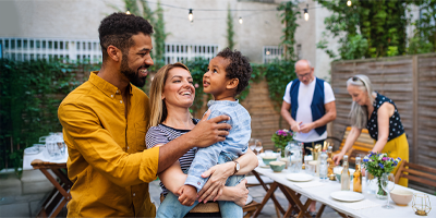 Young mom and dad holding their child at a family picnic