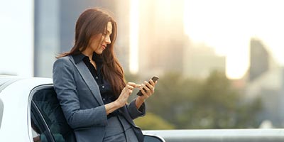Young woman in a suit browsing her smartphone.