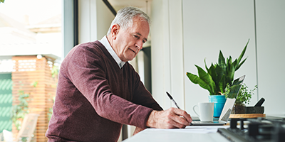 Retired man in maroon sweater evaluating qualified charitable distributions