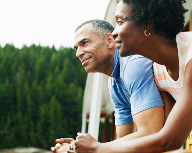 Middle-aged couple looking at scenery from a boat.
