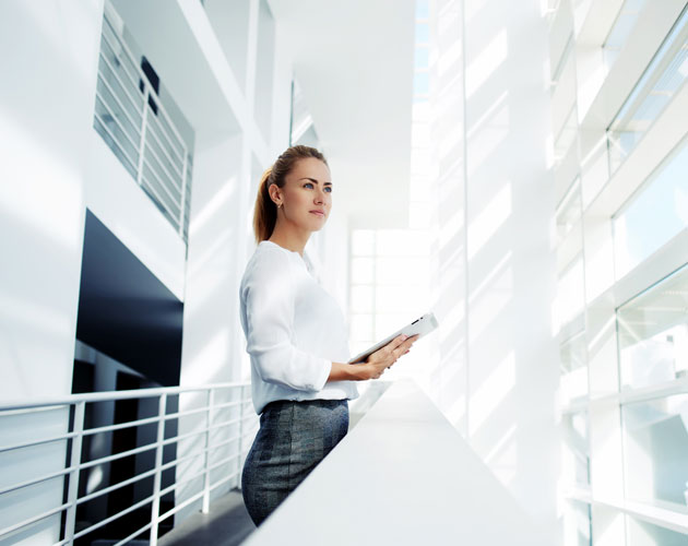 Young business woman looks out of modern office building
